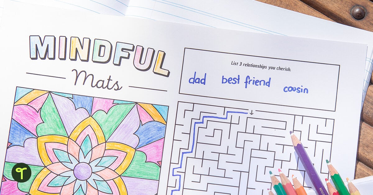 A mindful mat coloring activity sits on a student's desk with colored pencils piled on top
