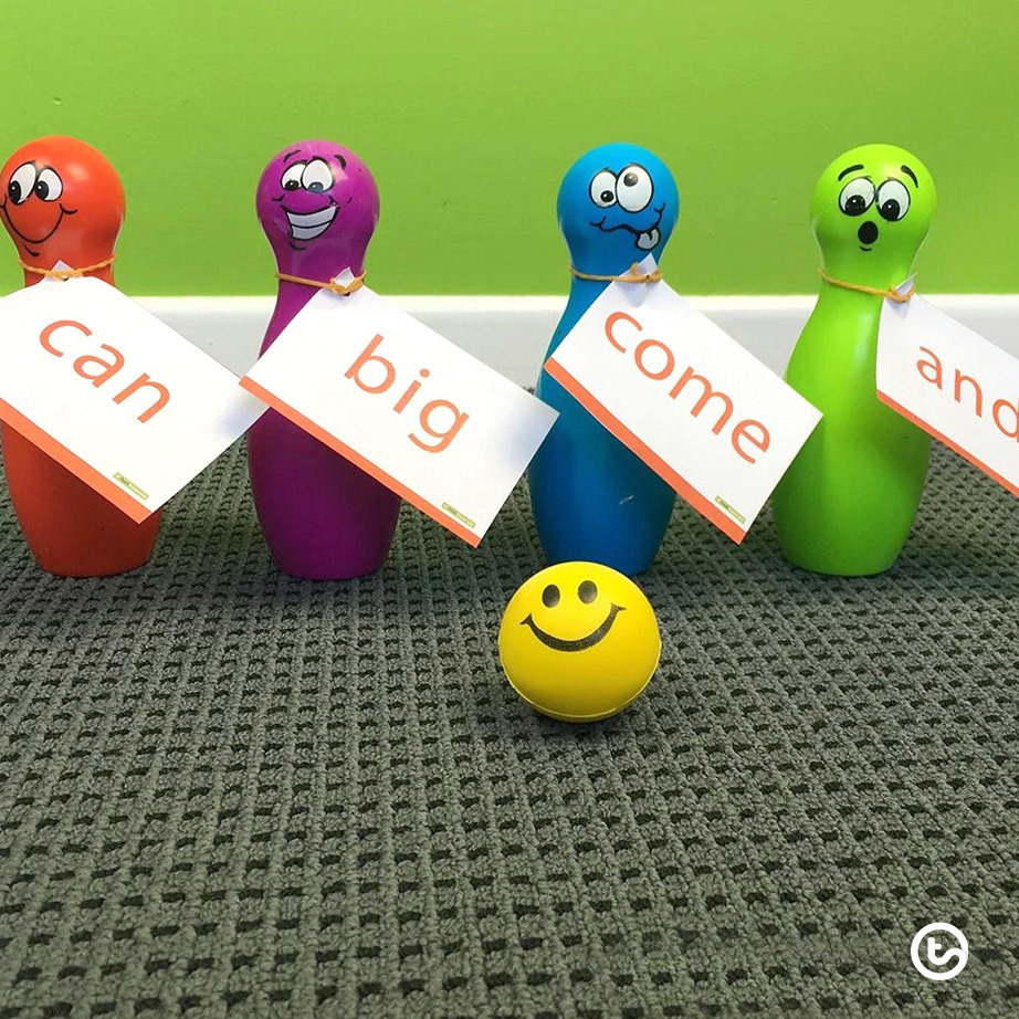 plastic bowling pins with sight words written on tags attached to them