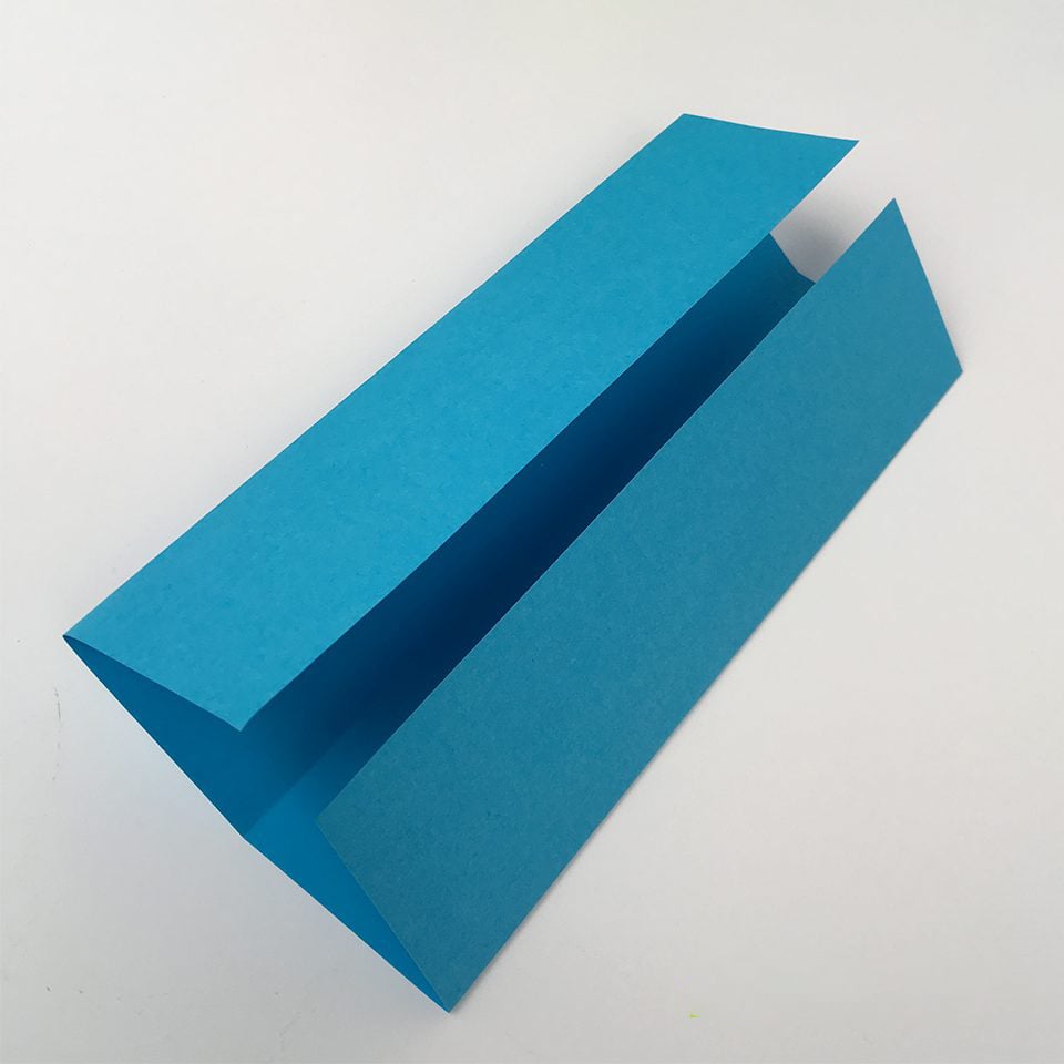 blue piece of paper folded as part of making an origami box