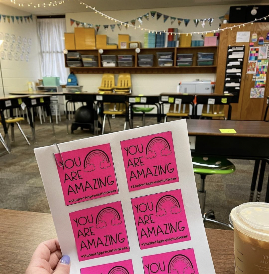 sticky notes that have been printed on held in a hand in a classroom