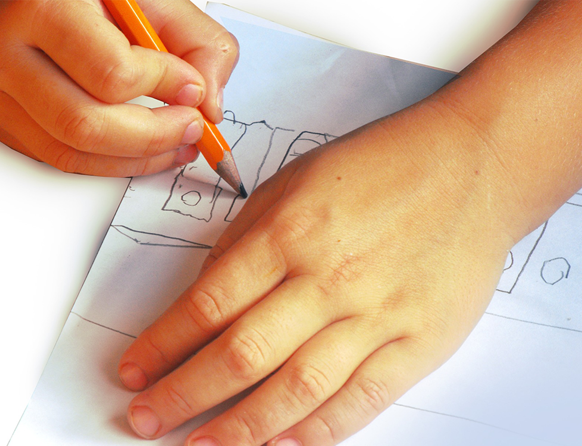 a student's hands are seen up close writing with one hand on a piece of paper