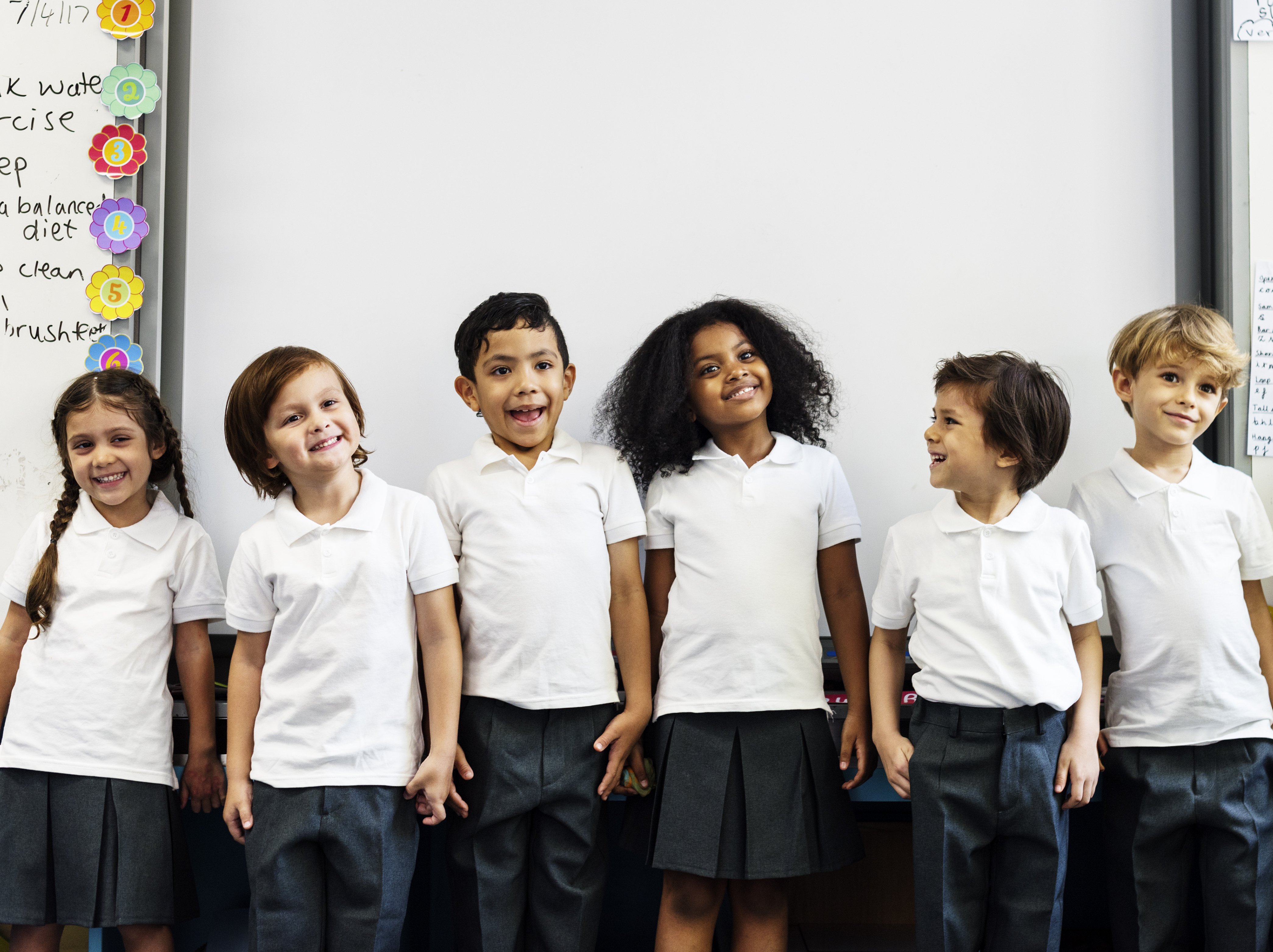 kids playing drama games, standing in a line in front of a whiteboard