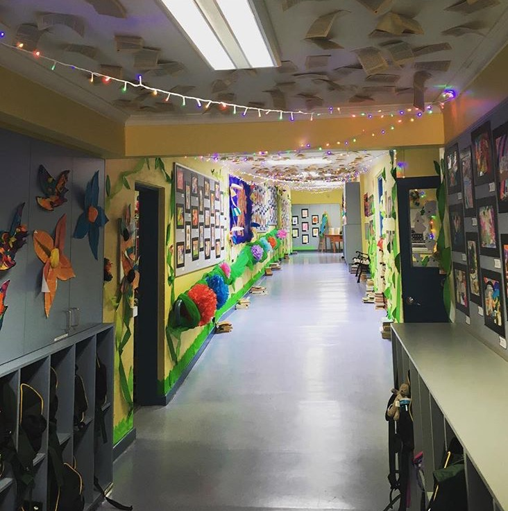 A school hallway decorated with art installations for a school art fair.