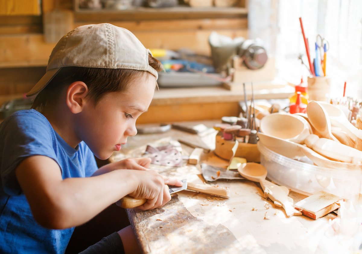 a boy learning to carve wood - holiday activities for creative thinking skills