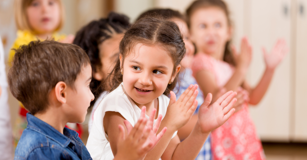 Kids watching a performance clapping