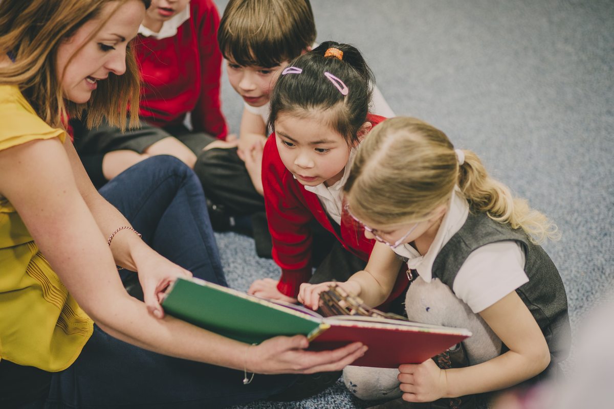 teacher reading to primary aged students