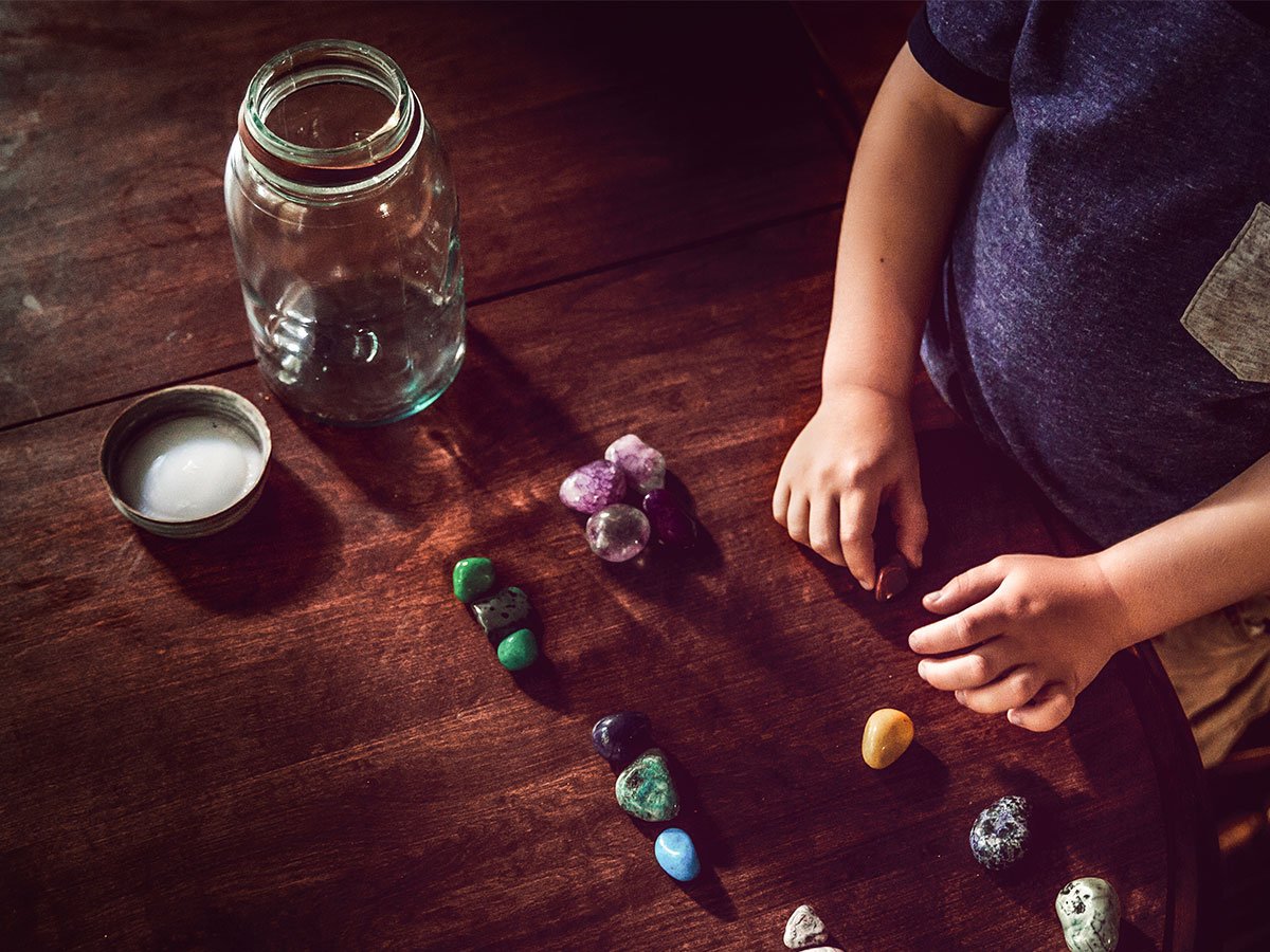 child subitizing rocks by counting them out into a jar