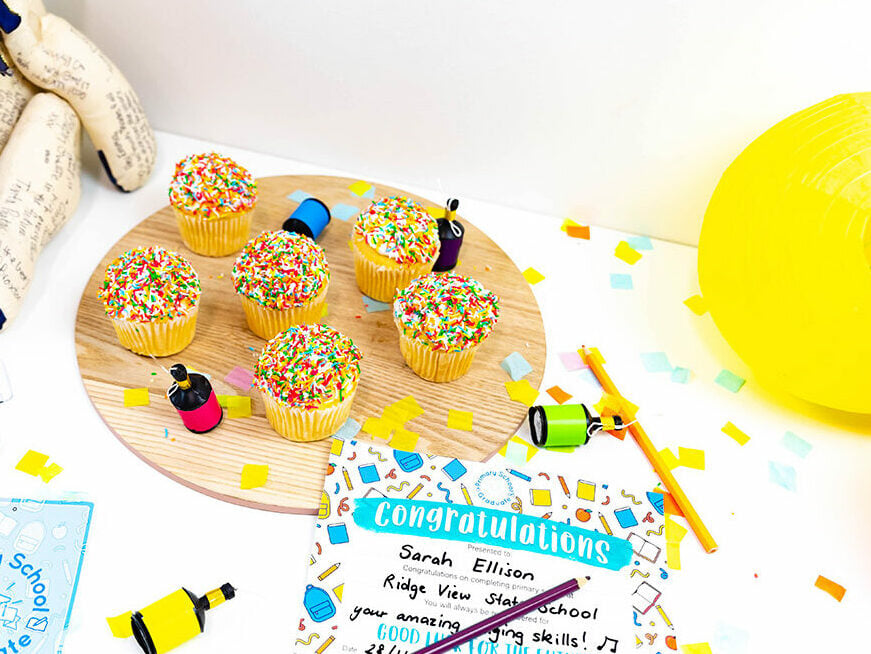 cupcakes sit on a round wooden plate beside a primary school graduation certificate 