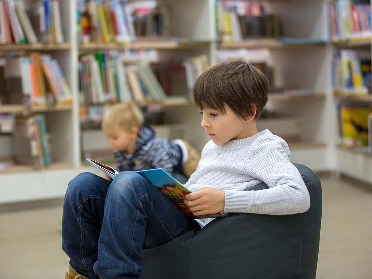 Library Activities for Kids - Boy reading in the library