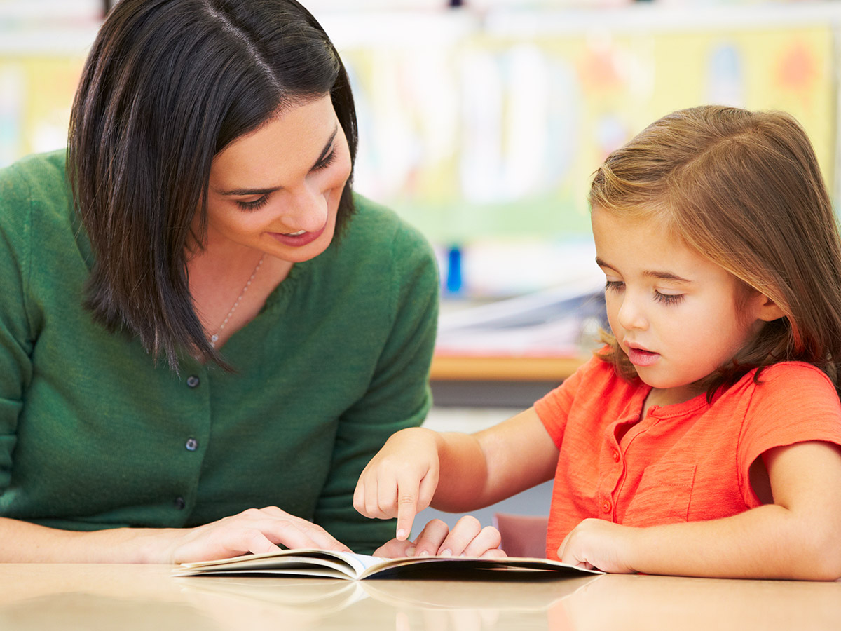 a teacher completing a running record for reading assessment