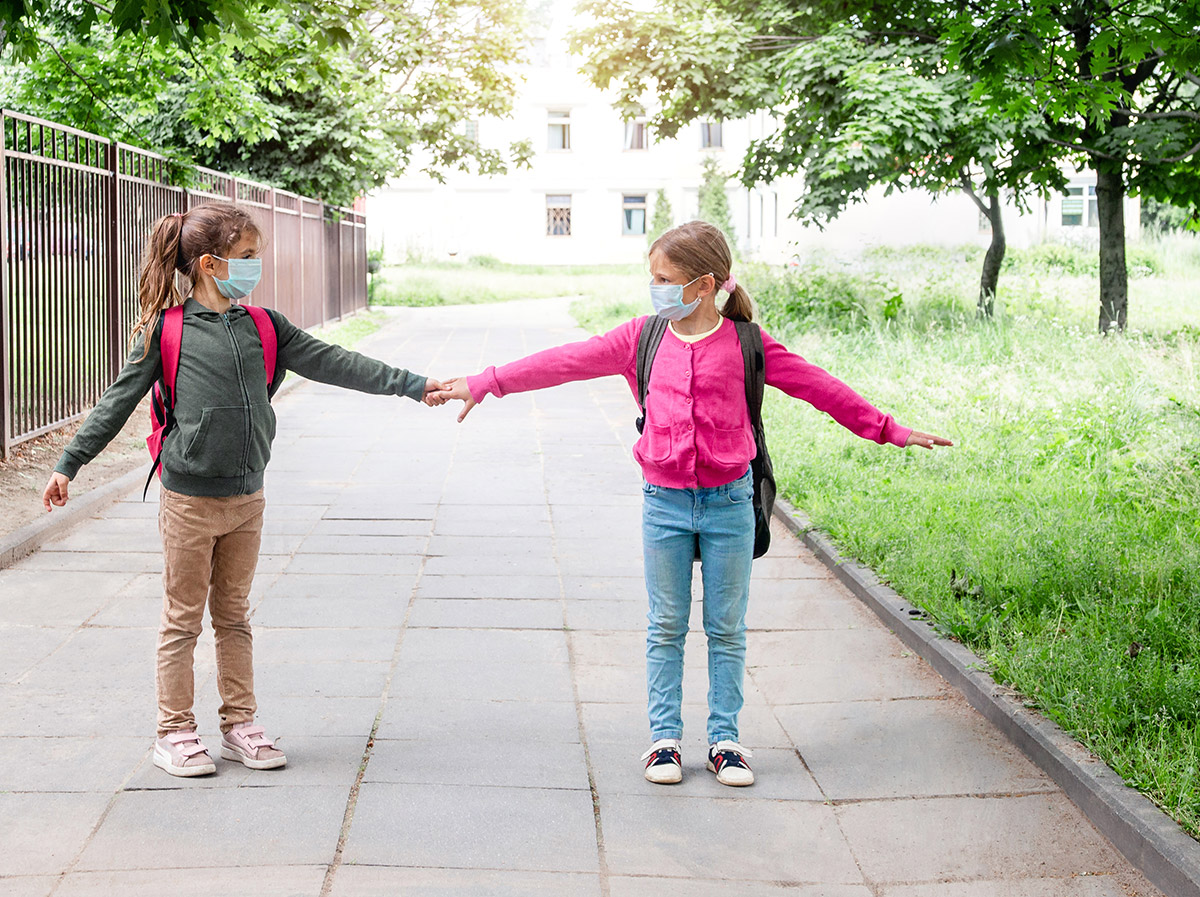 Kids measuring social distancing at school