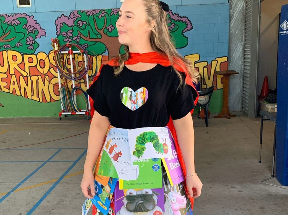 A woman wearing a handmade dress made of kids' book covers for Book Week