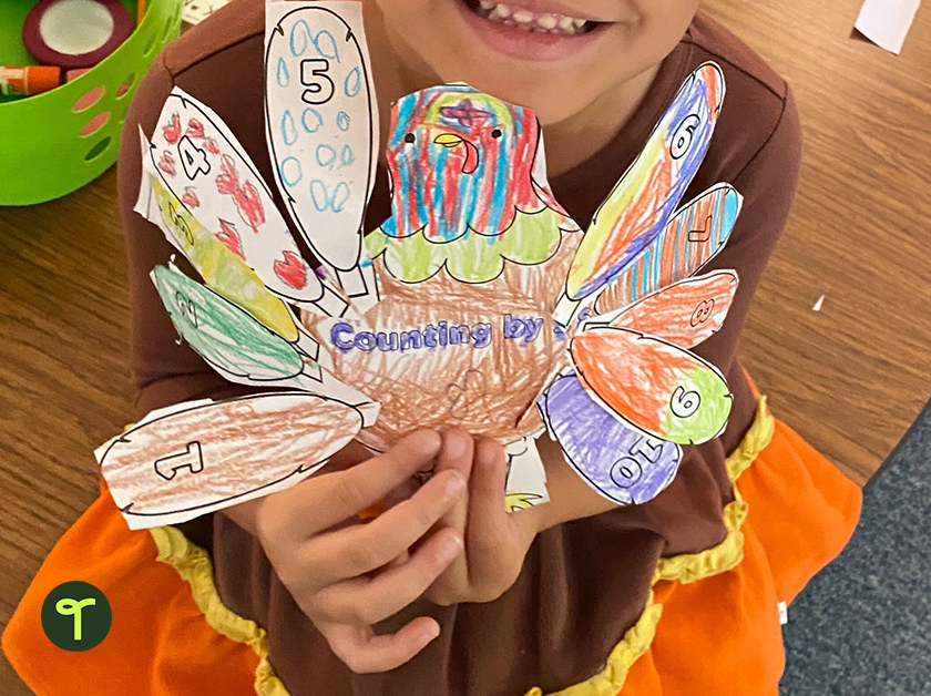 thanksgiving turkey counting activity for kids being held by kindergarten student