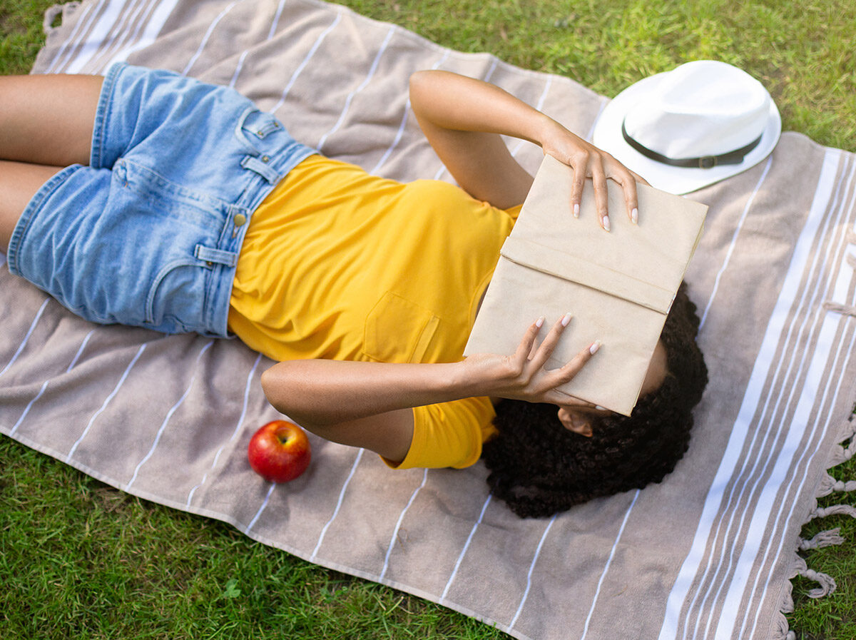 Lady reading a book on the grass