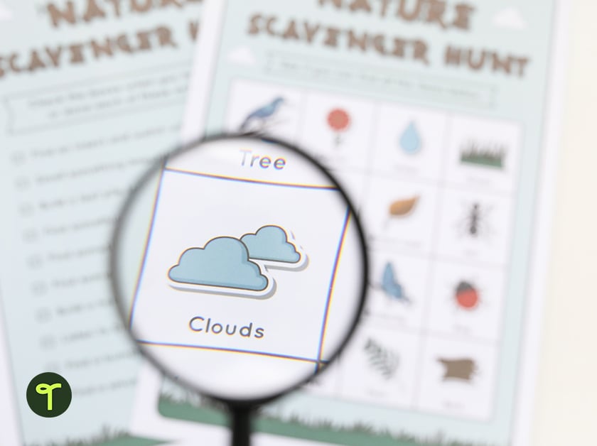 nature scavenger hunt on a table with a magnifying glass looking at the clouds section