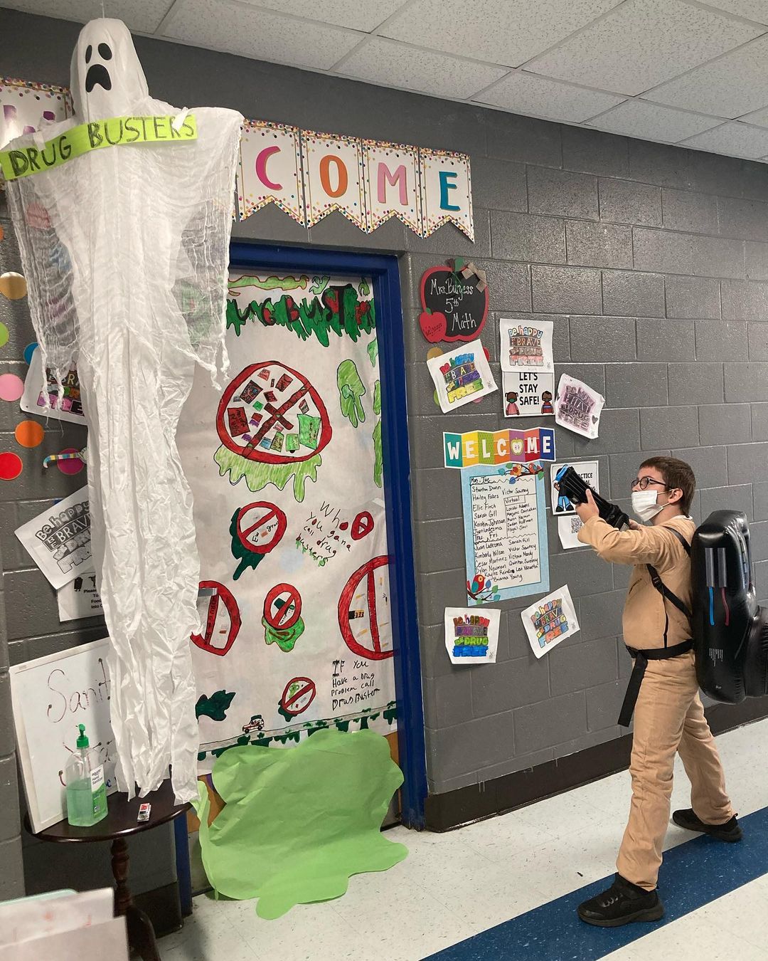 Student in front of Red Ribbon Week door with Ghost Busters costume.
