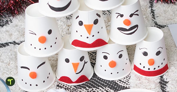 cups decorated for a snowman bowling game for kids are piled up in a pyramid