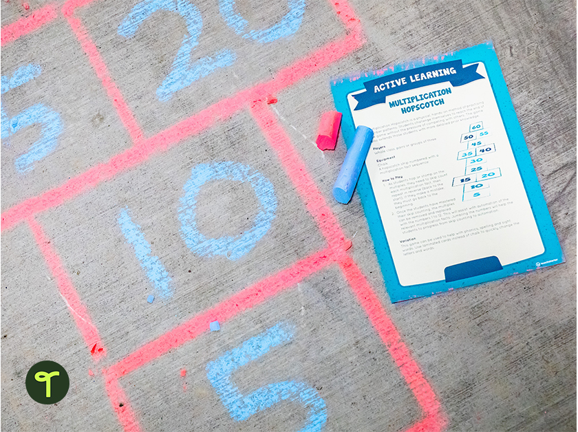 active learning maths game instructions sit on top of a hopscotch board drawn with colourful chalk