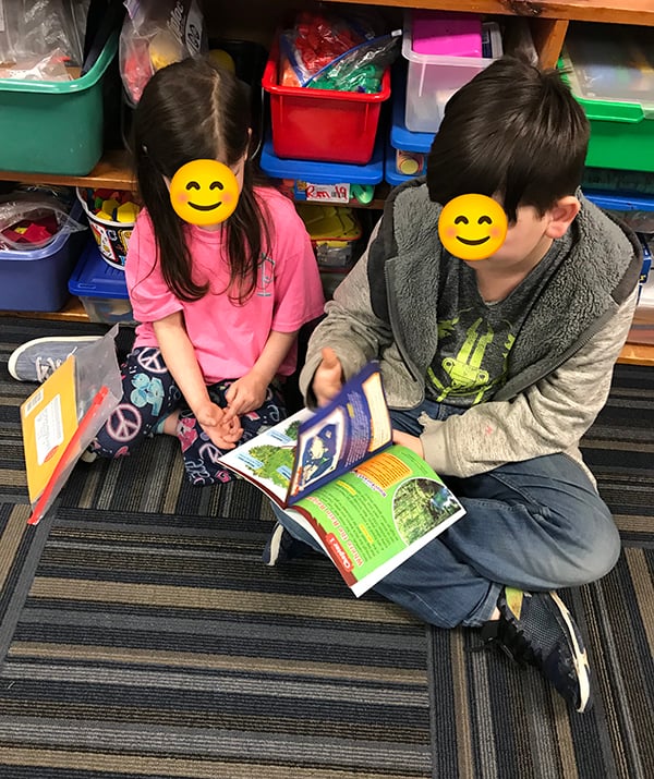 a 5th grader reads to a kindergartner on Read Across America Day in an elementary school