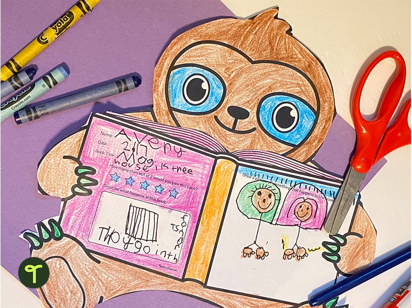little girl's book review on a sloth template with crayons and scissors