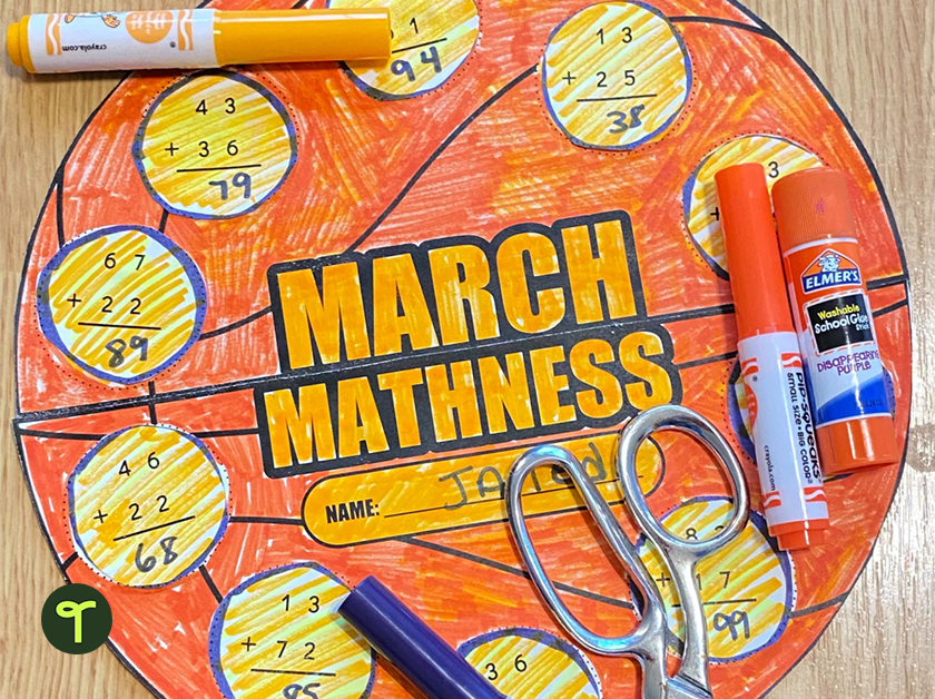 march mathness basketball shaped activity sheet sits on a table with scissors, markers and a glue stick