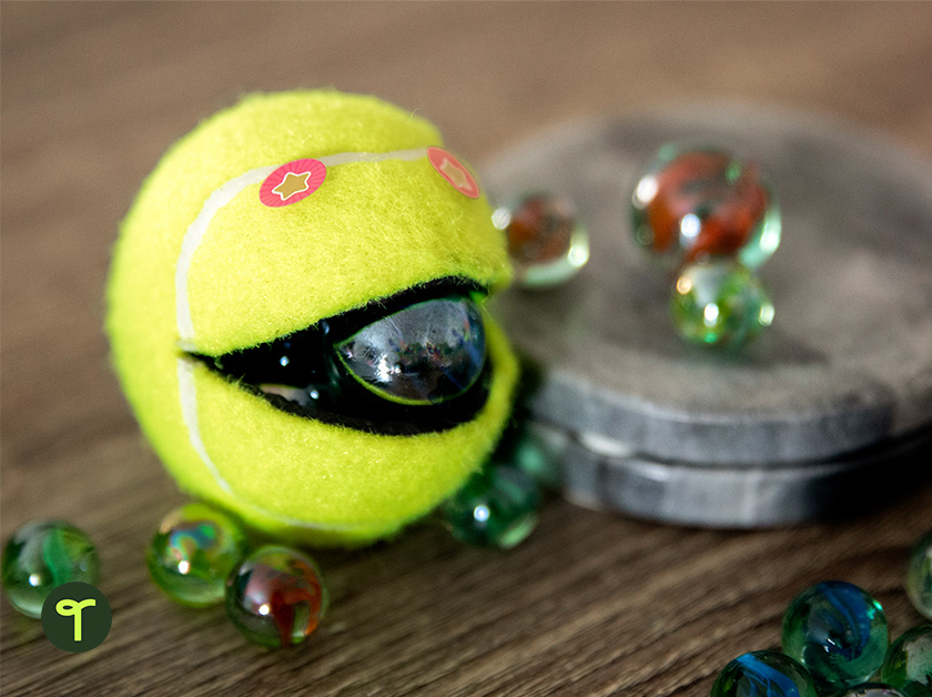 Tennis ball monster craft with marble in its mouth