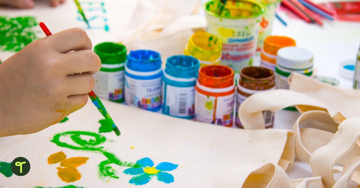 A kids painting a flower on a canvas tote bag