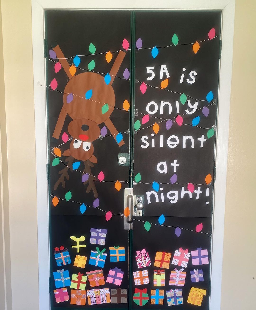 A Christmas classroom door decoration with a reindeer and presents titled '5A is only silent at night'