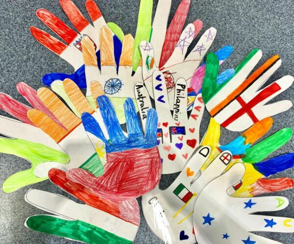 Hand print cut-outs showing different flags of the world