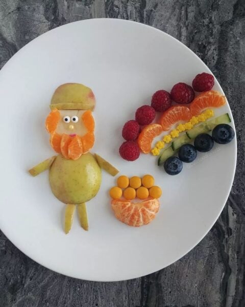 Leprechaun made out of fruit on a white plate