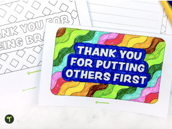 A primary teaching resource called Thank You For Putting Others First Colouring Sheet sits on a teacher's desk