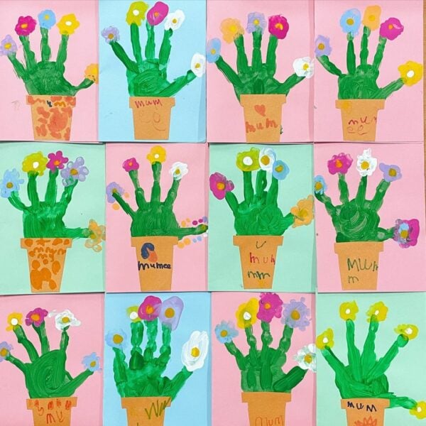A series of handmade cards with flowers on the front made from green painted handprints 
